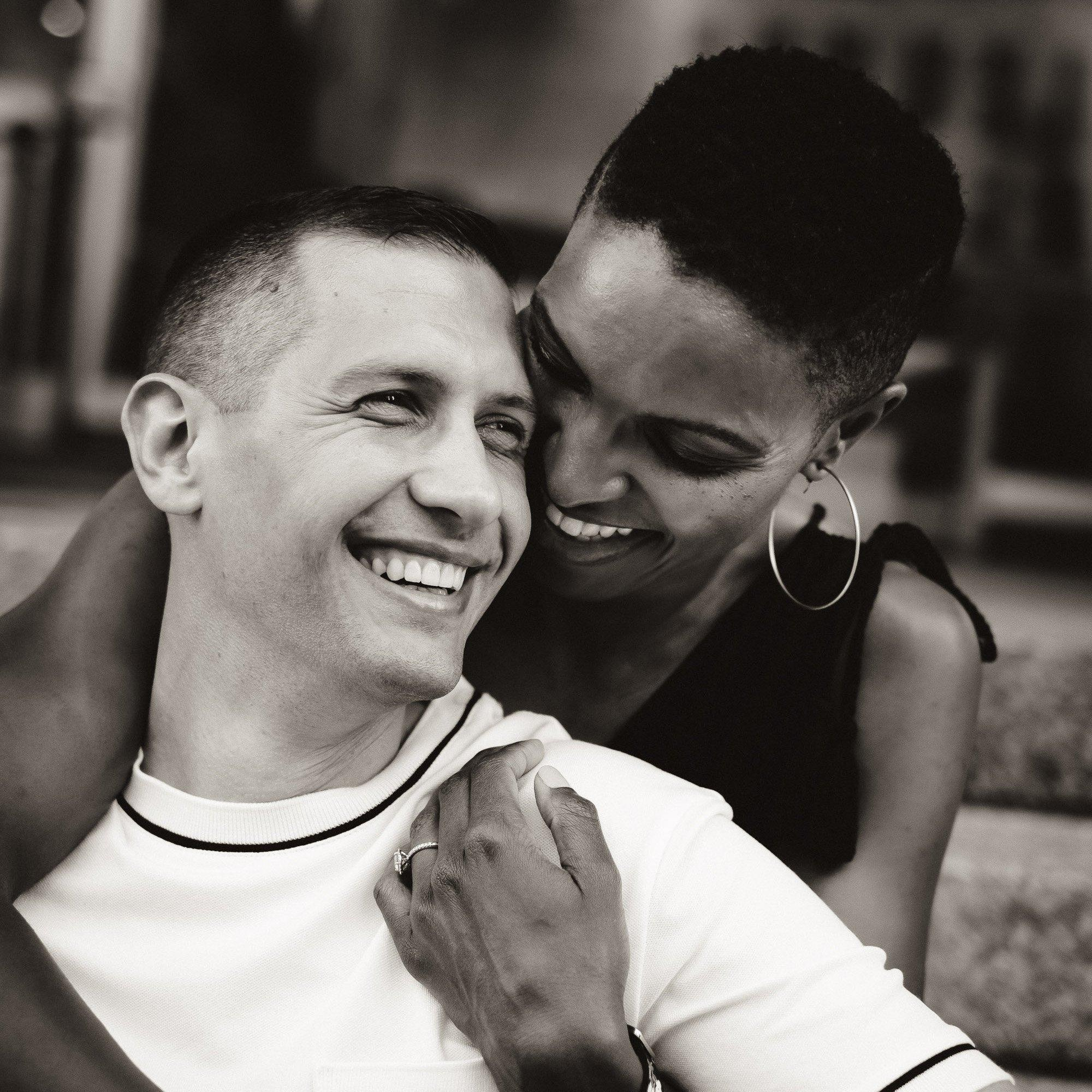 Mixed race engaged couple b&w laughing